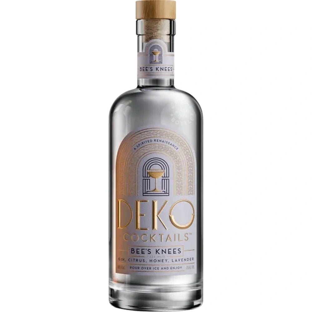 Deko Cocktails Bee’s Knees 750 ml bottle – clear gin cocktail with honey, lemon, and lavender accents on a gold surface.